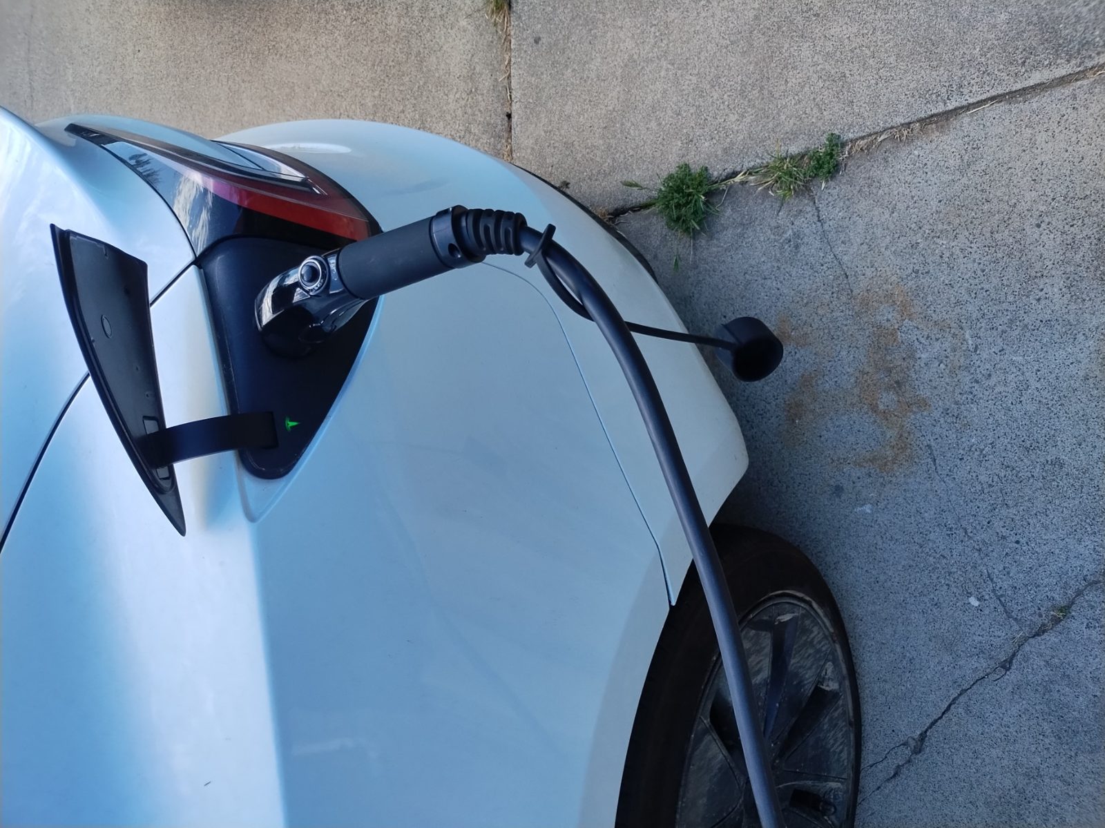 Close-up of a Level 2 charging cable connected to a Tesla charge port